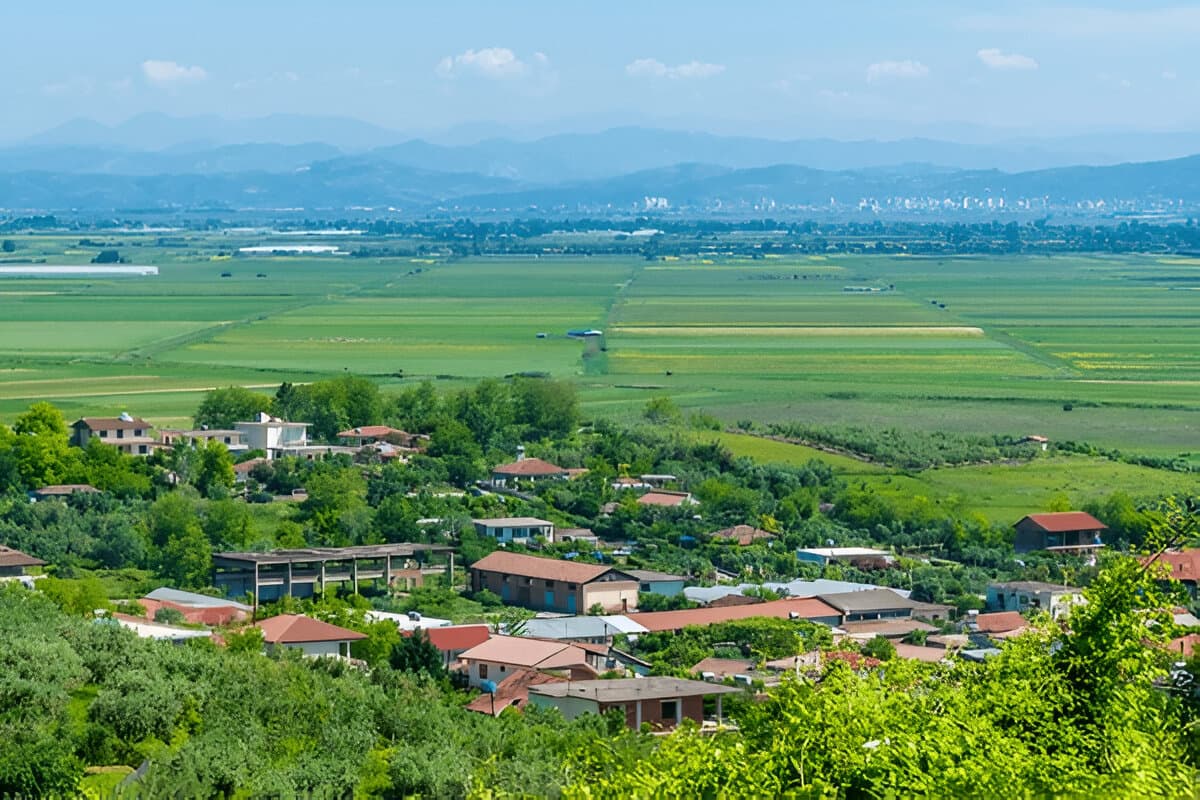 Modern apartment buildings and houses in Lushnje showcasing beautiful real estate properties